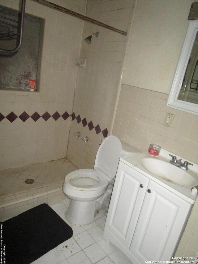 full bath featuring vanity, toilet, a stall shower, and tile walls