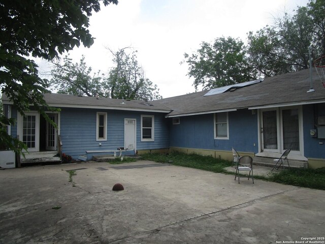 back of house featuring roof mounted solar panels, a patio, and entry steps