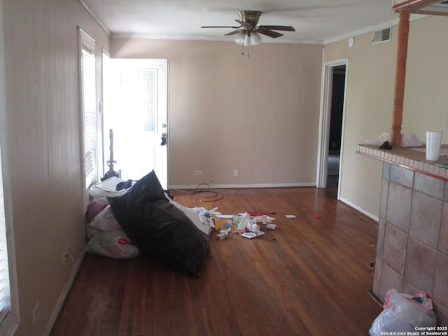unfurnished living room featuring wood finished floors, visible vents, crown molding, and a ceiling fan