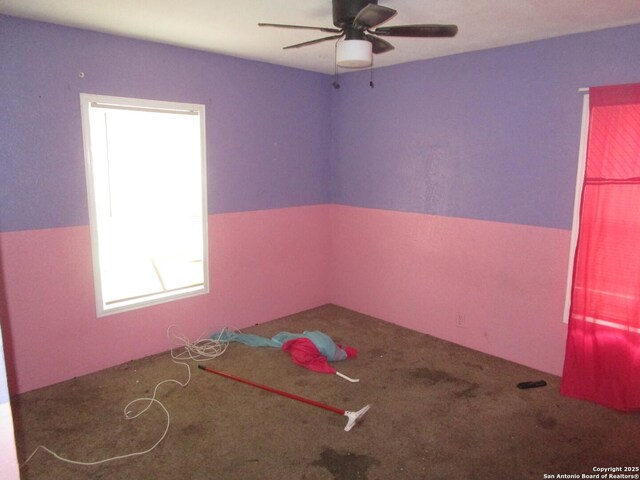 empty room with ceiling fan and carpet floors