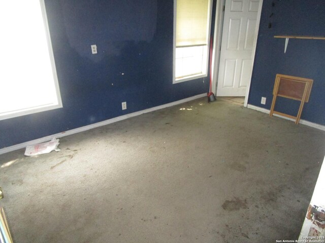 spare room with baseboards and carpet