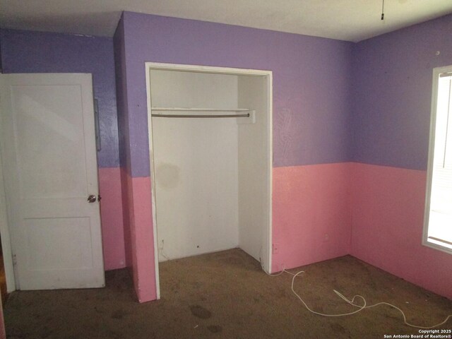 unfurnished bedroom featuring a closet and carpet flooring