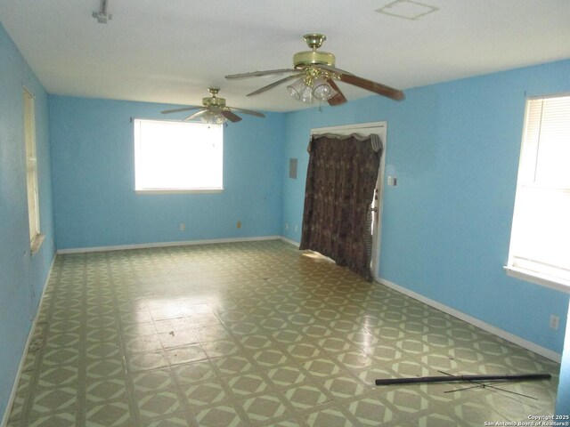 spare room featuring plenty of natural light, tile patterned floors, baseboards, and ceiling fan