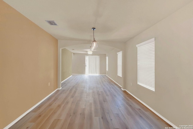 8906 Mission Brk, San Antonio, TX 78223 - interior space featuring arched walkways, wood finished floors, visible vents, and baseboards