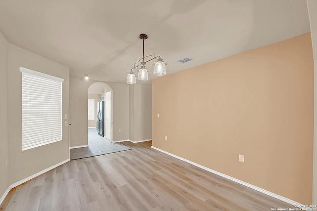 8906 Mission Brk, San Antonio, TX 78223 - unfurnished room with arched walkways, light wood-style floors, visible vents, and baseboards