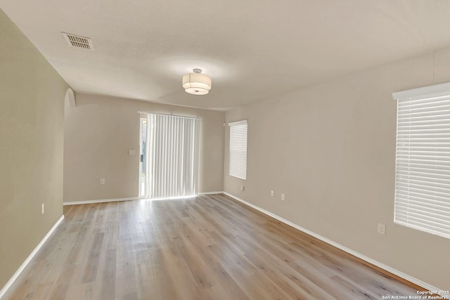 8906 Mission Brk, San Antonio, TX 78223 - empty room featuring arched walkways, visible vents, light wood finished floors, and baseboards