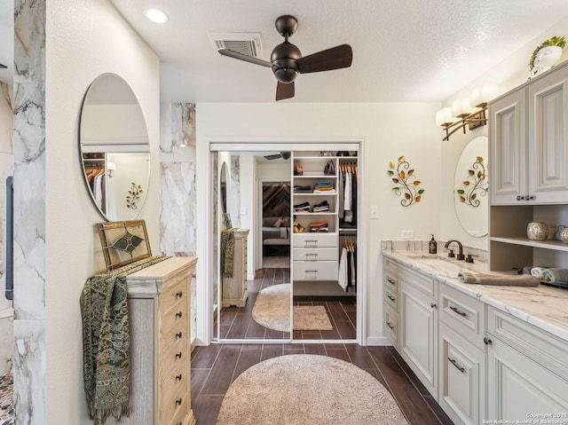 154 Elk Rdg, Canyon Lake, TX 78133 - bathroom featuring wood tiled floor, a spacious closet, visible vents, a ceiling fan, and vanity