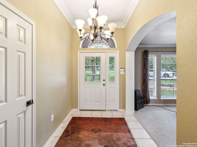 154 Elk Rdg, Canyon Lake, TX 78133 - foyer entrance featuring light tile patterned flooring, a chandelier, arched walkways, light colored carpet, and ornamental molding