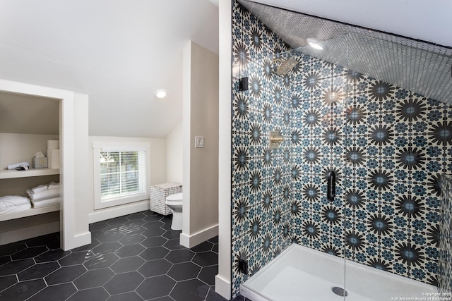 bathroom with tile patterned flooring, toilet, a stall shower, and baseboards