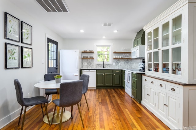 kitchen featuring open shelves, white appliances, green cabinetry, and visible vents