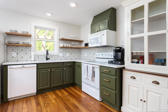 kitchen featuring open shelves, green cabinets, a sink, and white appliances