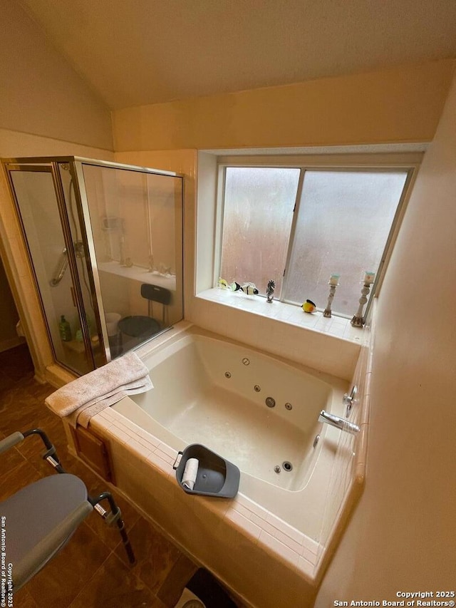 full bath with a shower stall, tile patterned floors, vaulted ceiling, a jetted tub, and toilet