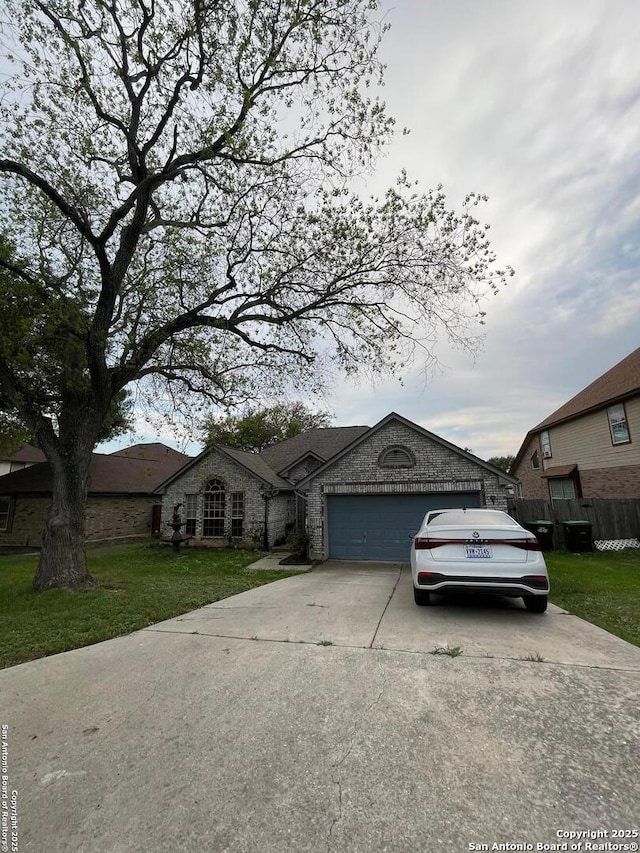 single story home featuring a front lawn, driveway, stone siding, fence, and a garage