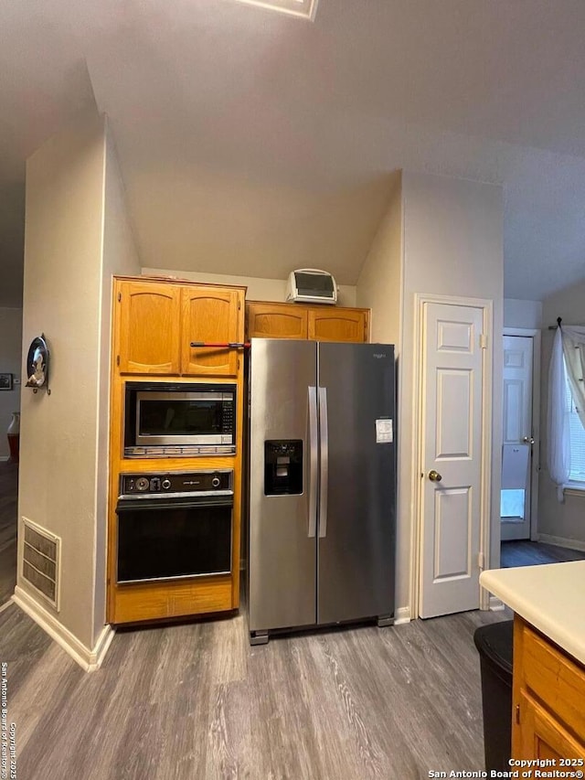 kitchen with light wood-type flooring, visible vents, appliances with stainless steel finishes, and baseboards
