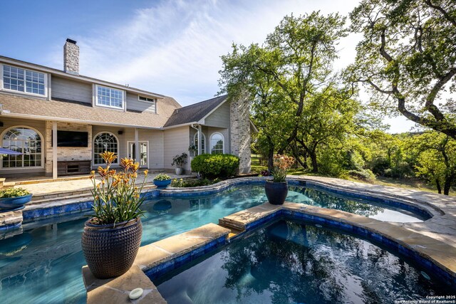 view of swimming pool featuring a patio and a pool with connected hot tub