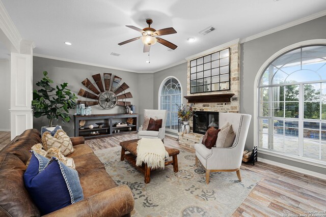 living area featuring wood finished floors, visible vents, a ceiling fan, ornamental molding, and baseboards