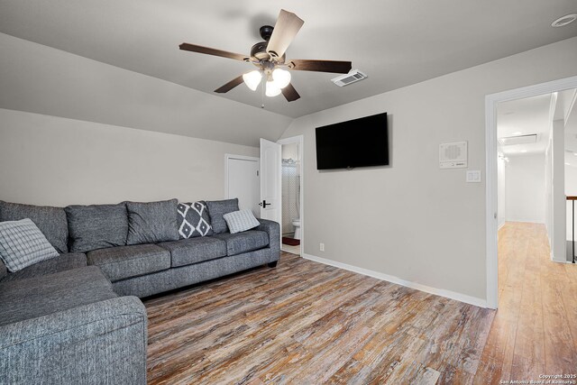 living room with vaulted ceiling, a ceiling fan, light wood-style floors, baseboards, and visible vents