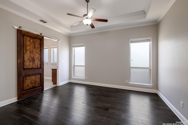 empty room with a raised ceiling, visible vents, a ceiling fan, and crown molding