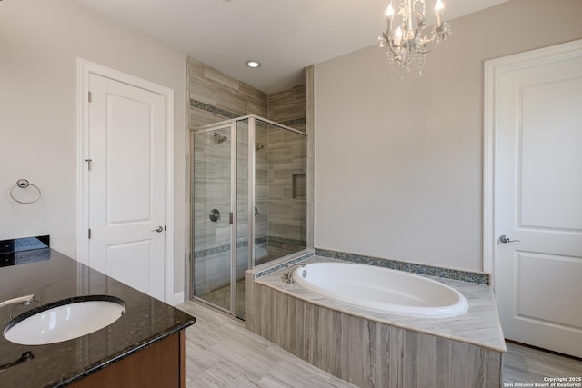 bathroom featuring recessed lighting, vanity, a chandelier, a garden tub, and a stall shower