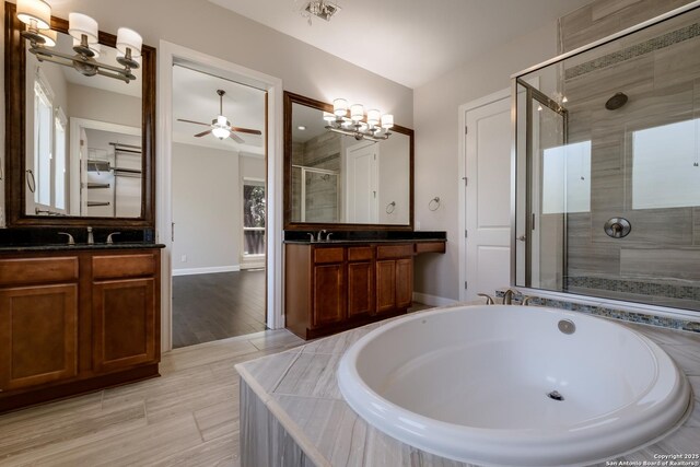 full bathroom with a garden tub, two vanities, ceiling fan, and a stall shower