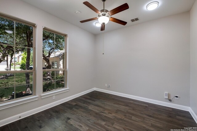 unfurnished room with visible vents, baseboards, dark wood-type flooring, and ceiling fan