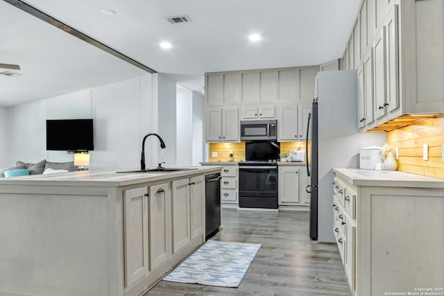 630 Nelson, Canyon Lake, TX 78133 - kitchen with light countertops, visible vents, a sink, decorative backsplash, and black appliances