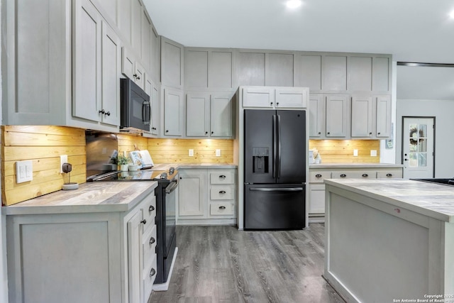 630 Nelson, Canyon Lake, TX 78133 - kitchen with light countertops, light wood-style floors, tasteful backsplash, and black appliances