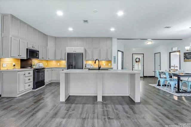 630 Nelson, Canyon Lake, TX 78133 - kitchen with fridge with ice dispenser, wood finished floors, a sink, stainless steel microwave, and black electric range oven