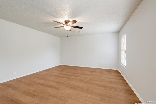 spare room featuring light wood-style floors, a textured ceiling, and a ceiling fan