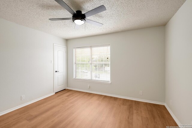 empty room featuring light wood-type flooring, a ceiling fan, baseboards, and a textured ceiling