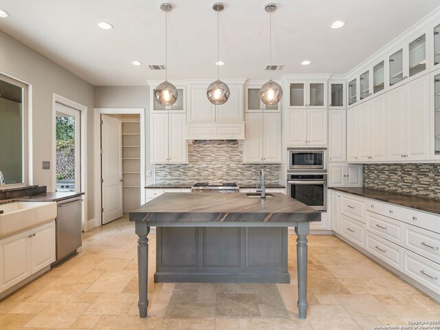 kitchen featuring a sink, stainless steel appliances, visible vents, and butcher block countertops