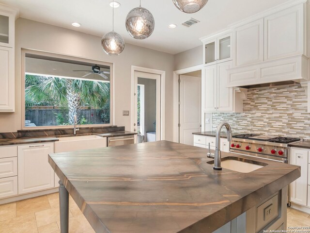 kitchen with backsplash, a ceiling fan, a sink, and visible vents