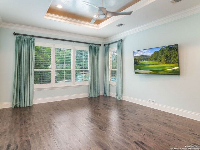 spare room with wood finished floors, visible vents, a ceiling fan, and ornamental molding