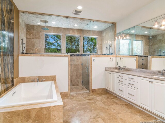 full bathroom featuring a shower stall, visible vents, a garden tub, and a sink