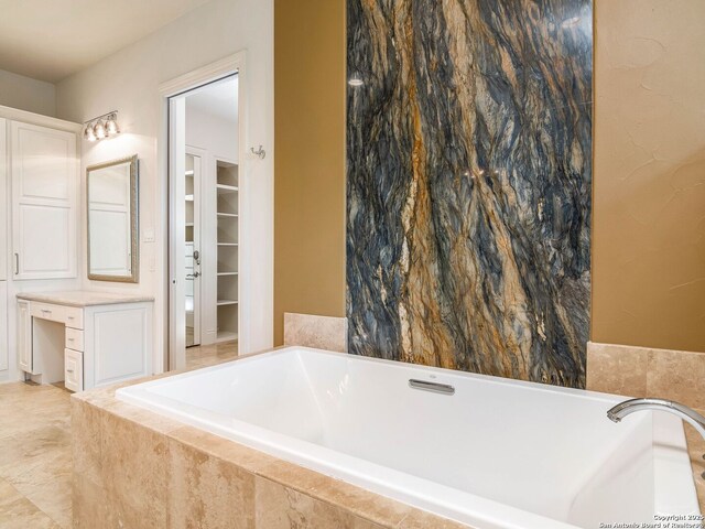 full bath featuring a walk in closet and tiled bath