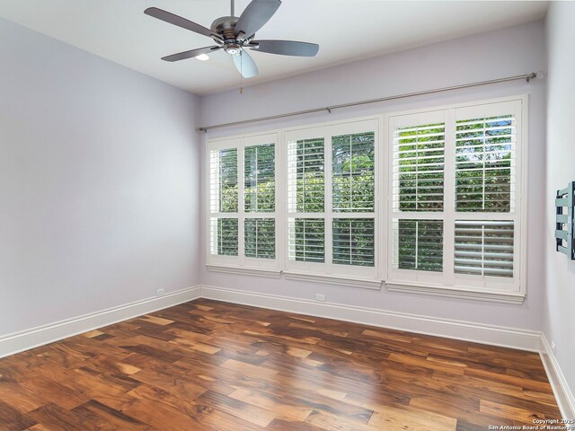 spare room with ceiling fan, baseboards, and wood finished floors
