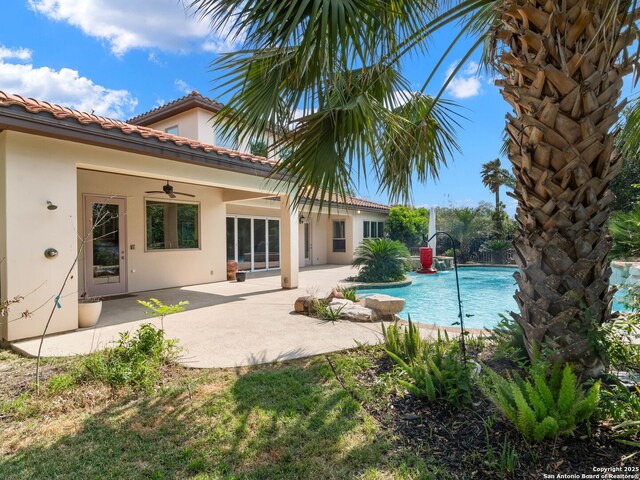 pool with a patio area and a ceiling fan