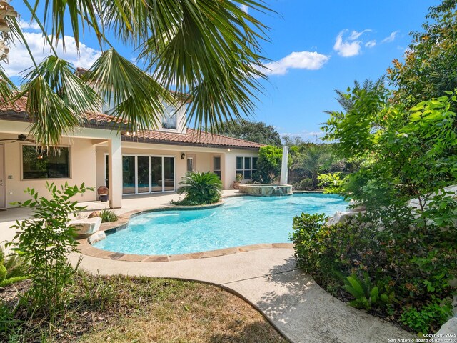view of swimming pool with a patio area and a pool with connected hot tub