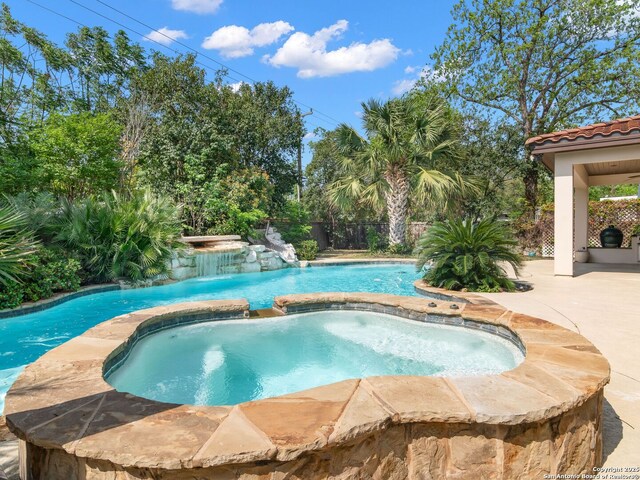 view of pool with a patio area, a pool with connected hot tub, and a fenced backyard