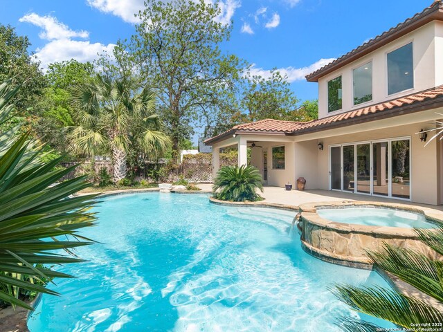 view of pool featuring a ceiling fan, a patio, and a pool with connected hot tub