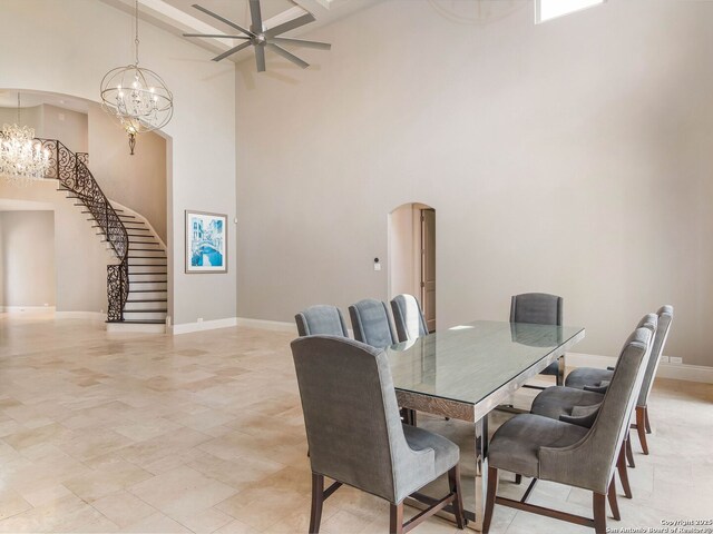 dining room with arched walkways, a towering ceiling, and baseboards