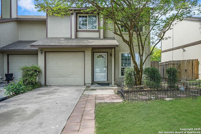 view of front of house with fence, driveway, roof with shingles, and a garage