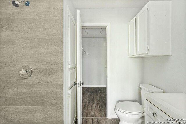 bathroom with baseboards, wood finished floors, toilet, and vanity