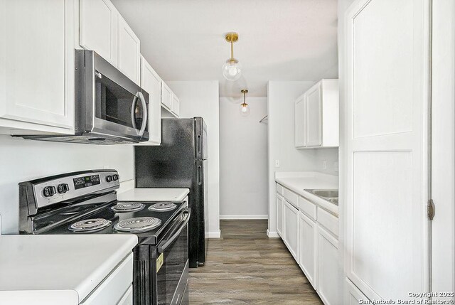 kitchen featuring white cabinets, stainless steel appliances, light wood-type flooring, and light countertops