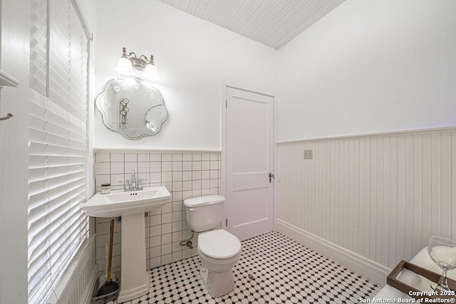 356 Kessler, New Braunfels, TX 78130 - bathroom featuring toilet, tile patterned floors, a wainscoted wall, and a sink