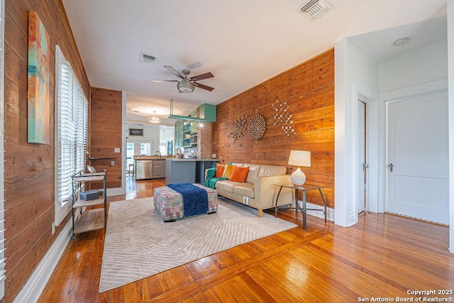 356 Kessler, New Braunfels, TX 78130 - living room with wooden walls, a ceiling fan, and visible vents