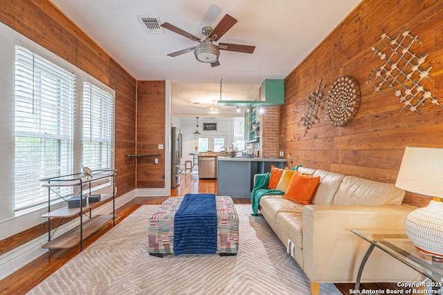 356 Kessler, New Braunfels, TX 78130 - living room with wood walls, wood finished floors, visible vents, a ceiling fan, and baseboards