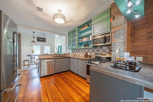 356 Kessler, New Braunfels, TX 78130 - kitchen with open shelves, hardwood / wood-style flooring, green cabinets, stainless steel appliances, and visible vents