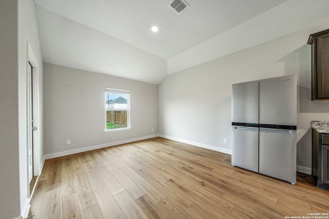 6507 Thorpe, Converse, TX 78109 - interior space featuring light wood-style flooring, baseboards, lofted ceiling, visible vents, and freestanding refrigerator