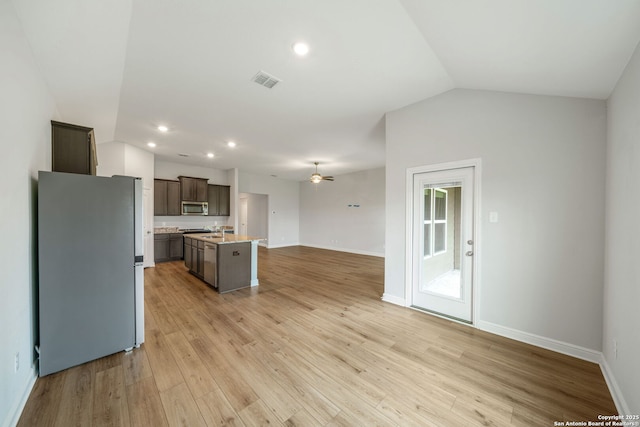 kitchen featuring open floor plan, a center island with sink, light countertops, appliances with stainless steel finishes, and visible vents